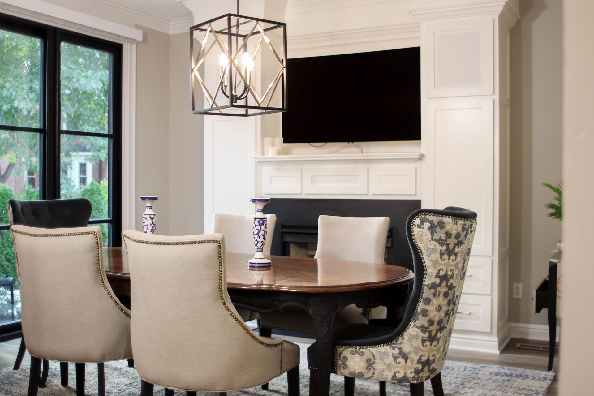 Elegant dining room with upholstered chairs, wooden table, and modern pendant light.